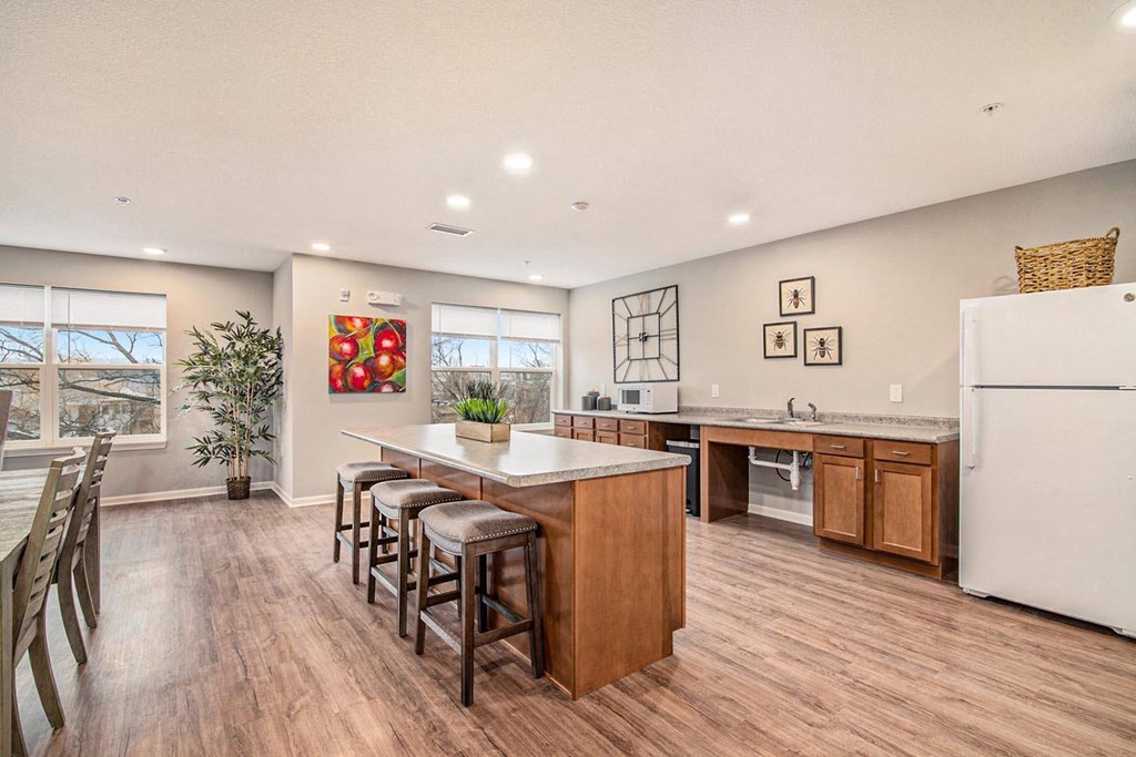 a kitchen with a center island and a bar with stools