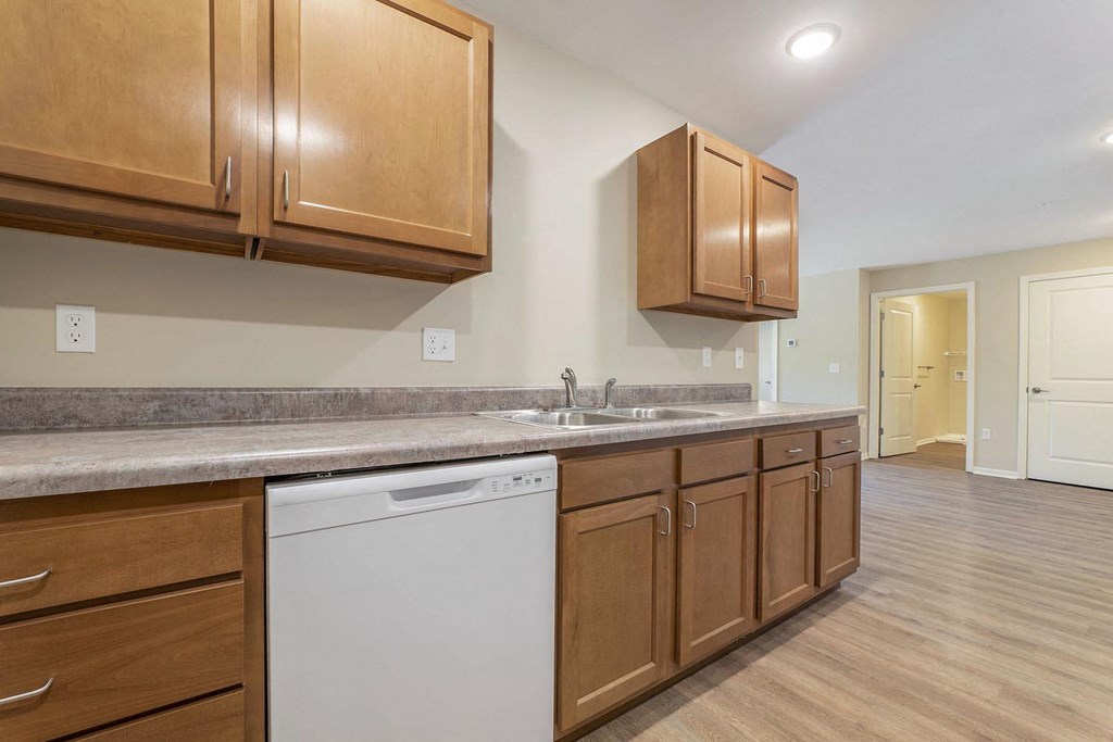 a kitchen with wooden cabinets and a white dishwasher