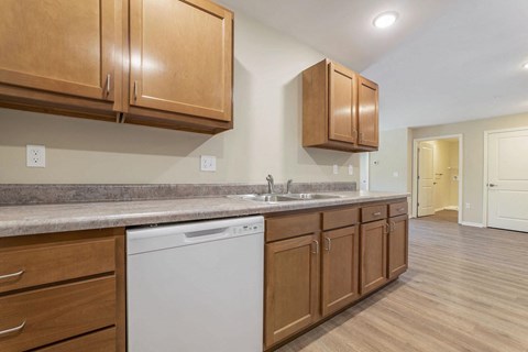 a kitchen with wooden cabinets and a white dishwasher
