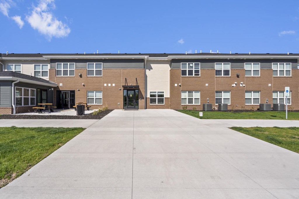 a large brick building with a concrete walkway in front of it