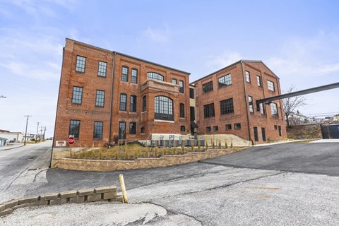 A large red brick building with a parking lot in front.
