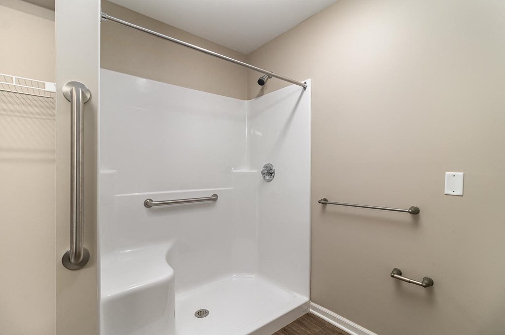 a white bathroom with a shower and a sink