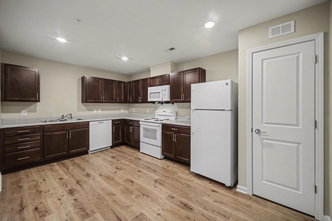 A kitchen with brown cabinets and white appliances.
