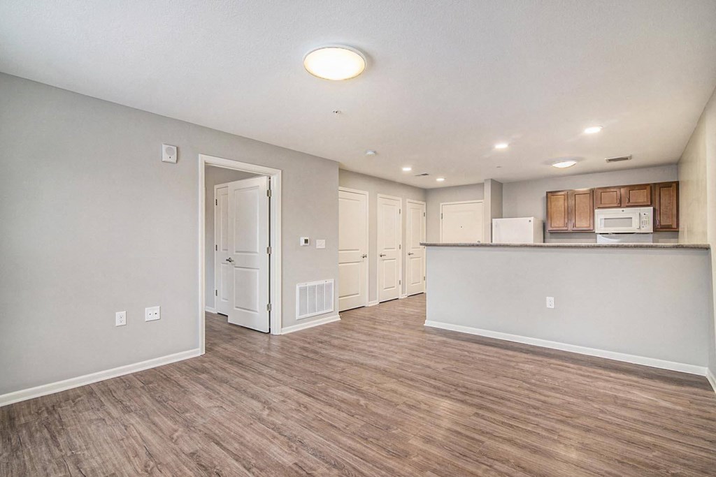the living room and kitchen of a new home with wood flooring