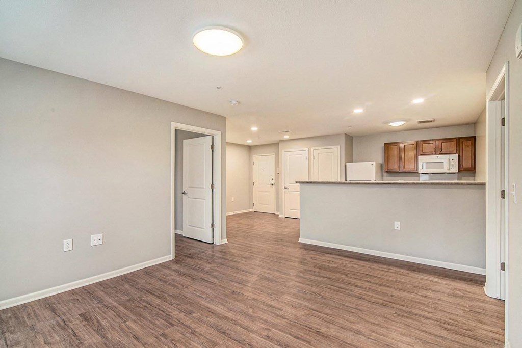 the living room and kitchen of a new home with a wood floor