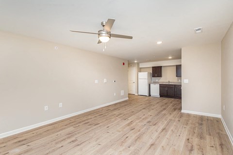 A room with a ceiling fan and wooden flooring.