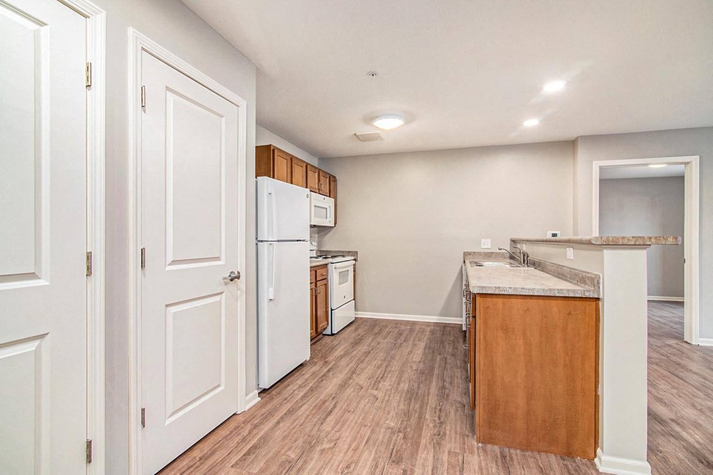 an empty kitchen with white cabinets and a white refrigerator