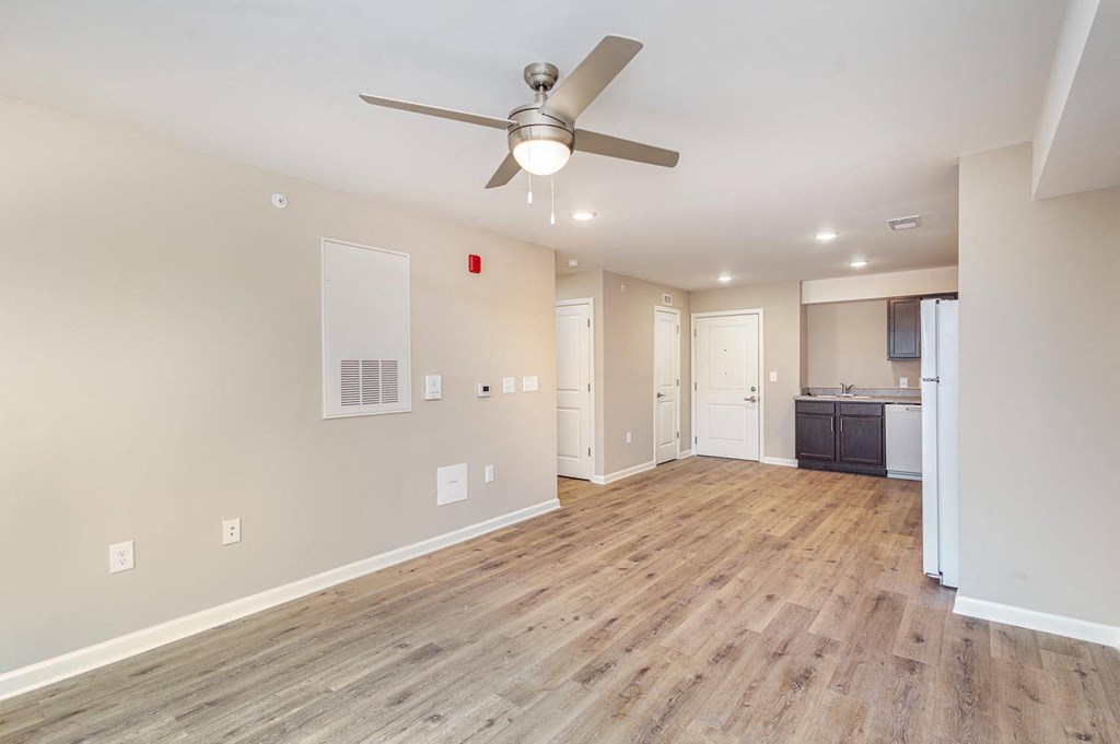 A room with a ceiling fan and wooden flooring.