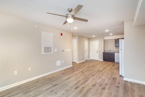 A room with a ceiling fan and wooden flooring.