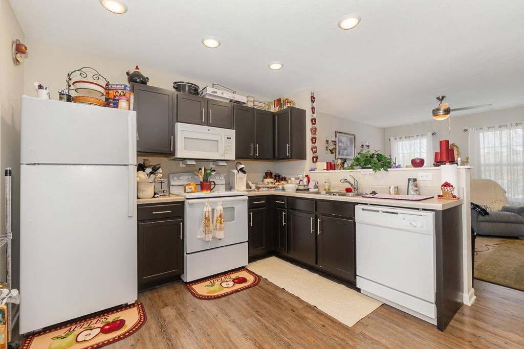 a kitchen with dark cabinets and white appliances
