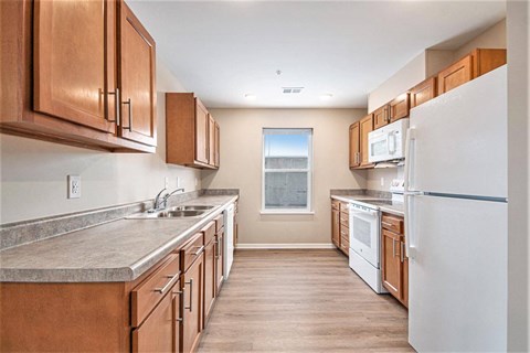 A kitchen with brown cabinets and a white refrigerator.
