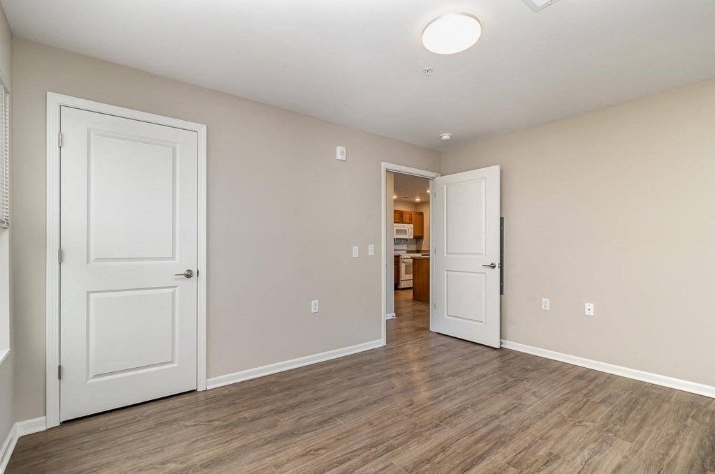 a bedroom with two doors and a door to a bathroom