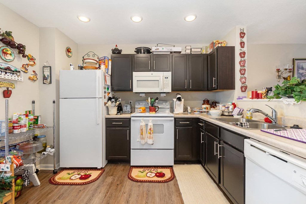 a kitchen with white appliances and black cabinets