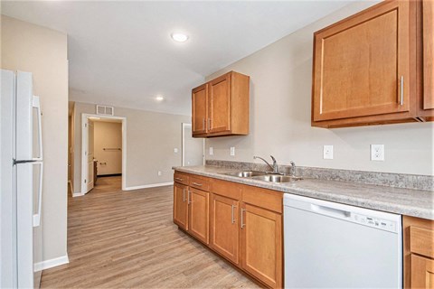 A kitchen with wooden cabinets and a white dishwasher.