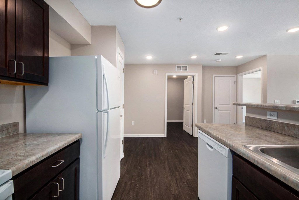 a renovated kitchen with white appliances and wooden floors