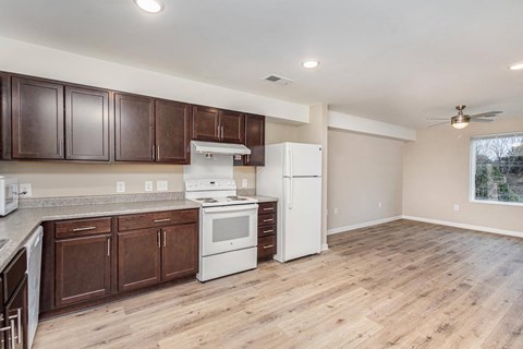 A kitchen with white appliances and wooden cabinets.