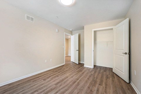 an empty bedroom with a closet and a door to a bathroom