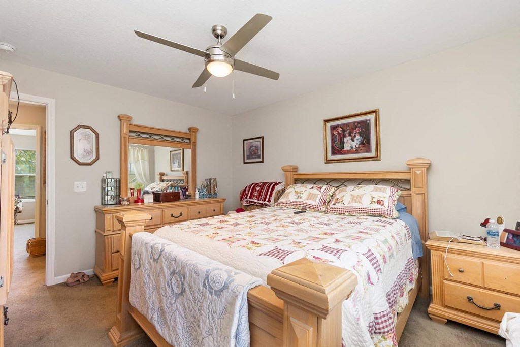 a bedroom with a bed and a ceiling fan