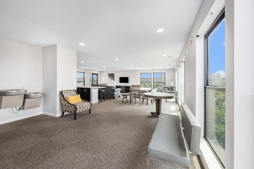 a room with a table and chairs and a large window