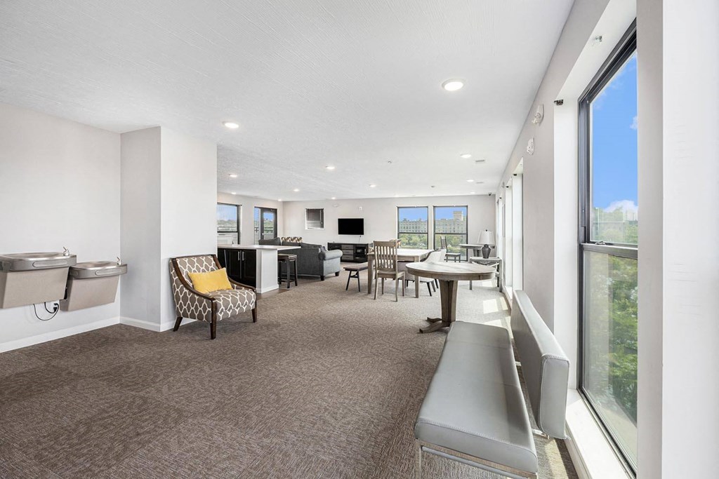 a room with a table and chairs and a large window