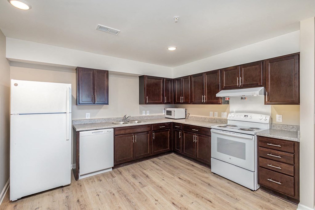 A kitchen with brown cabinets and a white refrigerator.