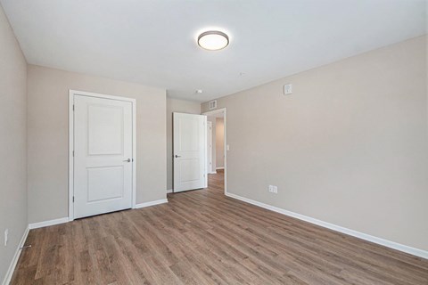 A room with wooden flooring and white walls.