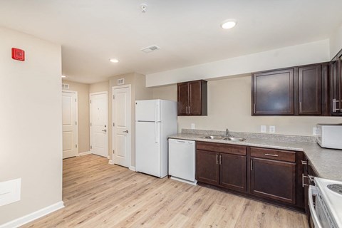 A kitchen with white appliances and brown cabinets.
