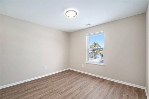 A room with a window showing a tree and a blue sky.