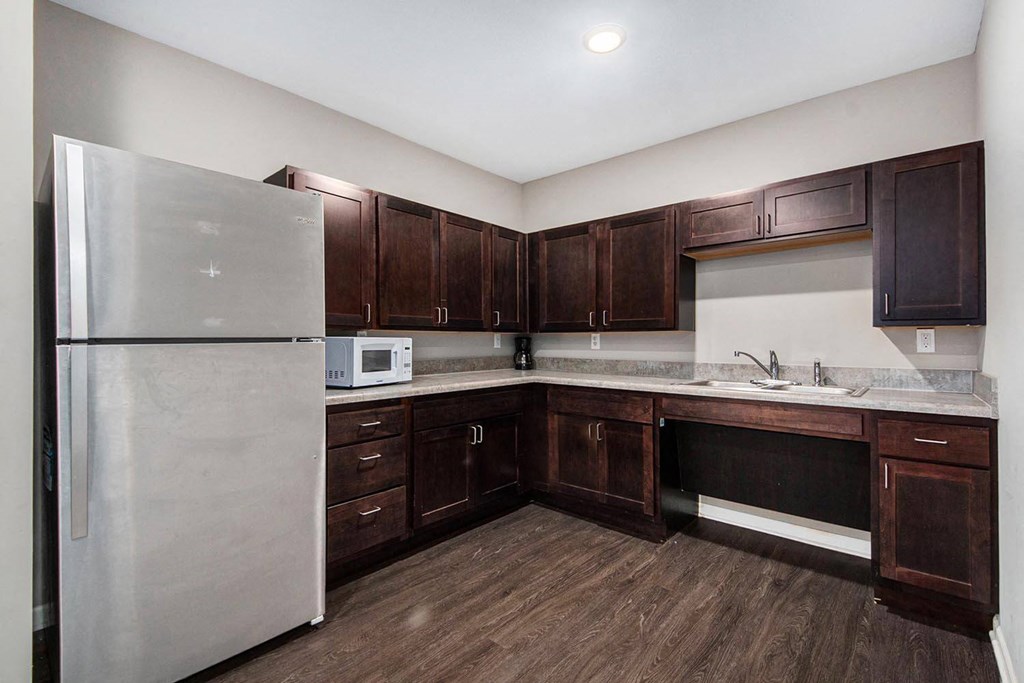 a kitchen with wooden cabinets and a stainless steel refrigerator