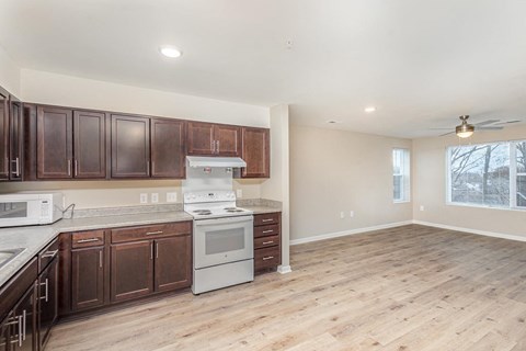 A kitchen with wooden cabinets and a white stove top oven.