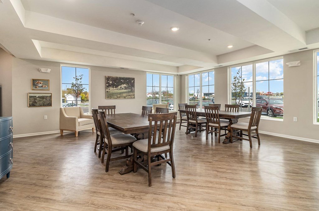 a dining room with a table and chairs and large windows