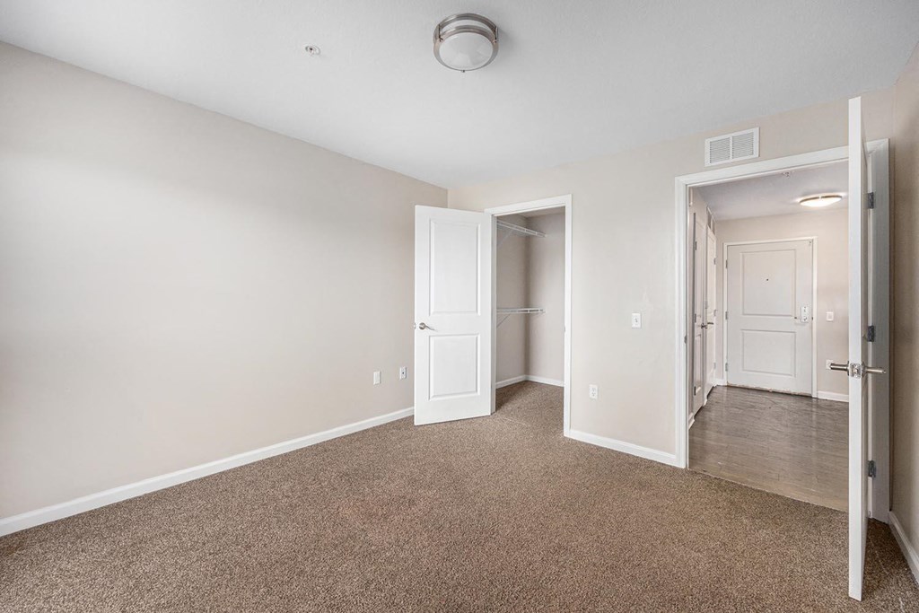 a bedroom with a closet and a door to a hallway