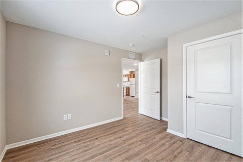 A room with a white door and a light on the ceiling.