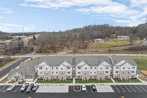 A large white building with a parking lot in front.