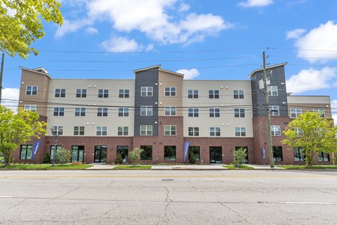 A large multi-story building with a parking lot in front.