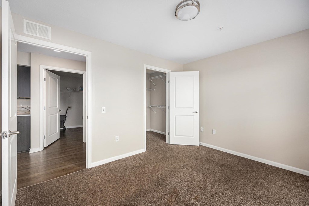 an empty living room with carpet and a closet