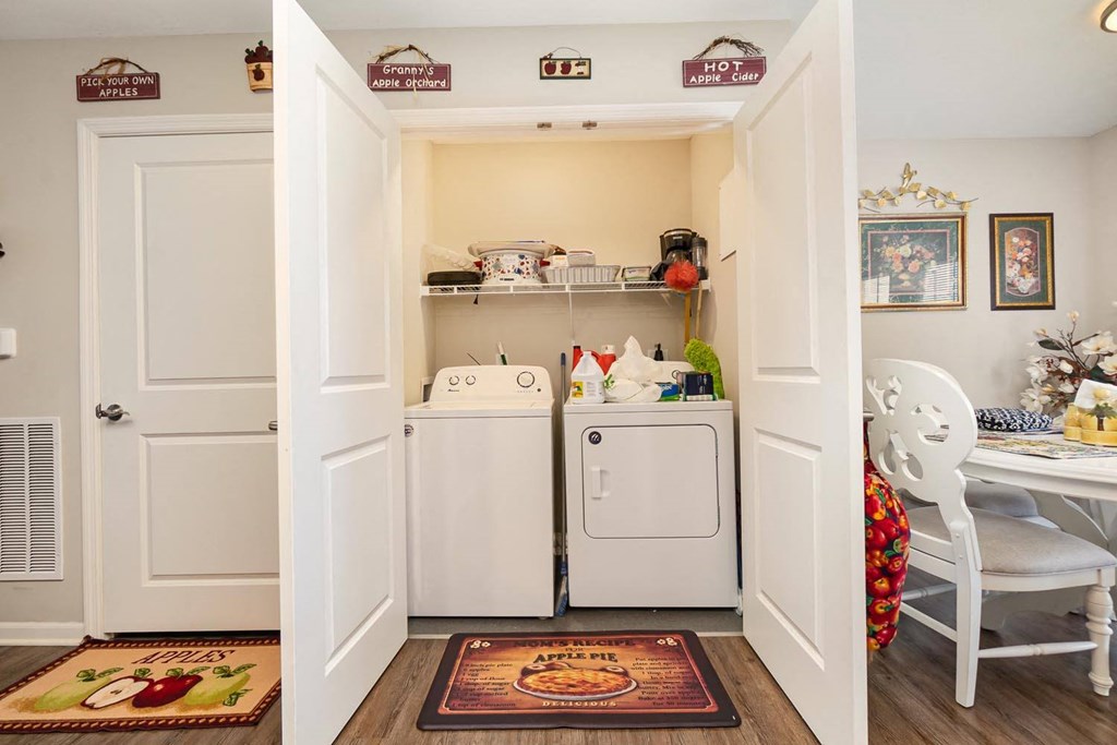 a laundry room with a washer and dryer and a table and chairs