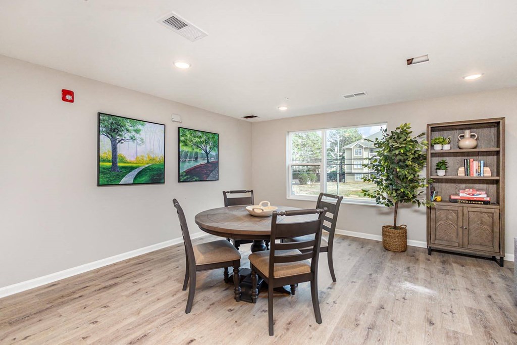 A dining room with a table and chairs.