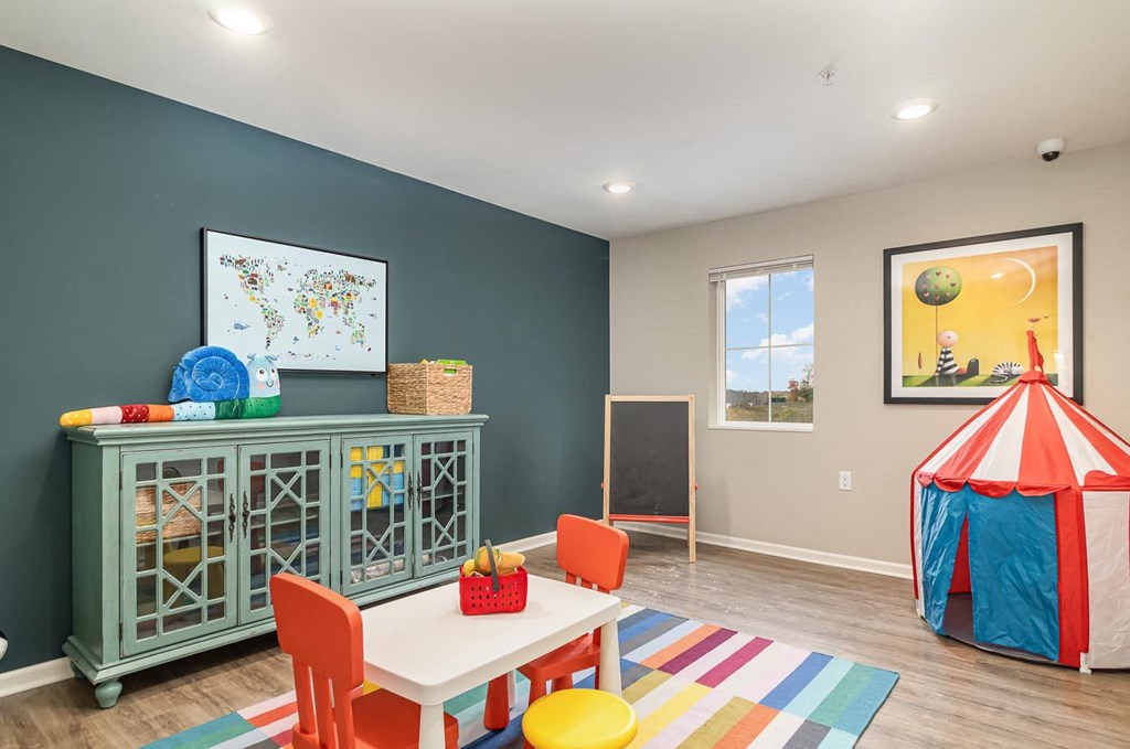 a play room with a tent and a table and chairs