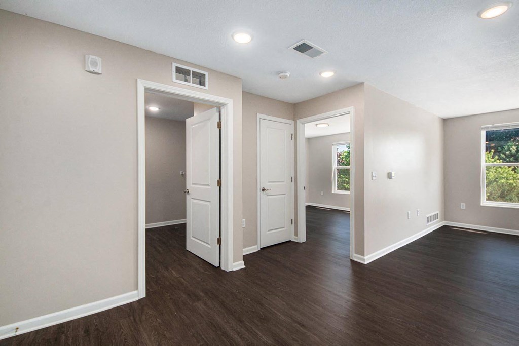 an empty room with white walls and wood floors