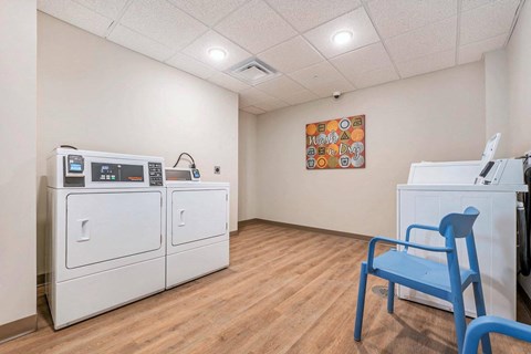 a room with white tables and chairs and a painting on the wall