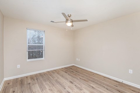 A room with a ceiling fan and a window.