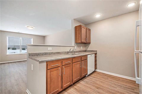 A kitchen with wooden cabinets and a white dishwasher.