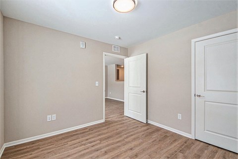 A room with a white door and a light on the ceiling.