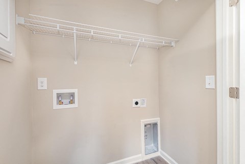 A white shelving unit is mounted on the wall above a white door.