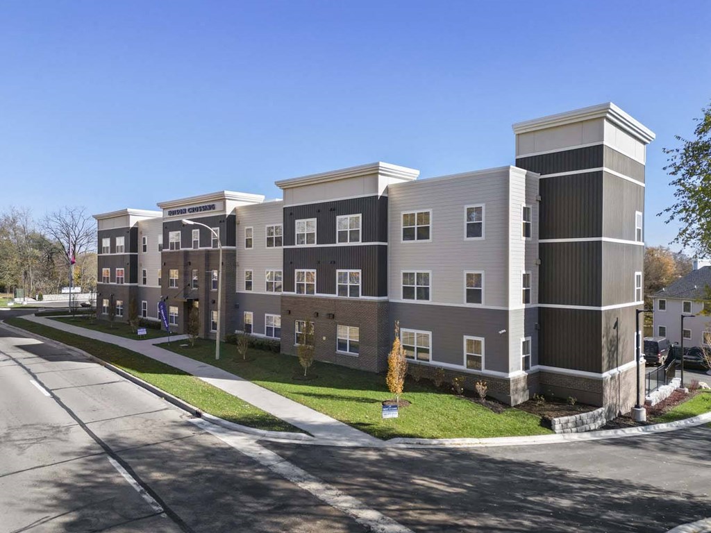 a row of three story apartment buildings on the side of a street