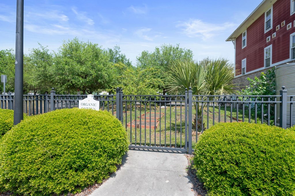 the entrance to a yard with a wrought iron fence