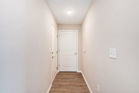 A white door is at the end of a hallway.