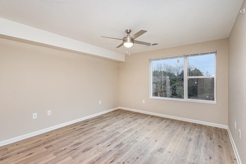 A room with a ceiling fan and a window.