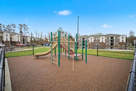 A playground with a slide and a green pole.